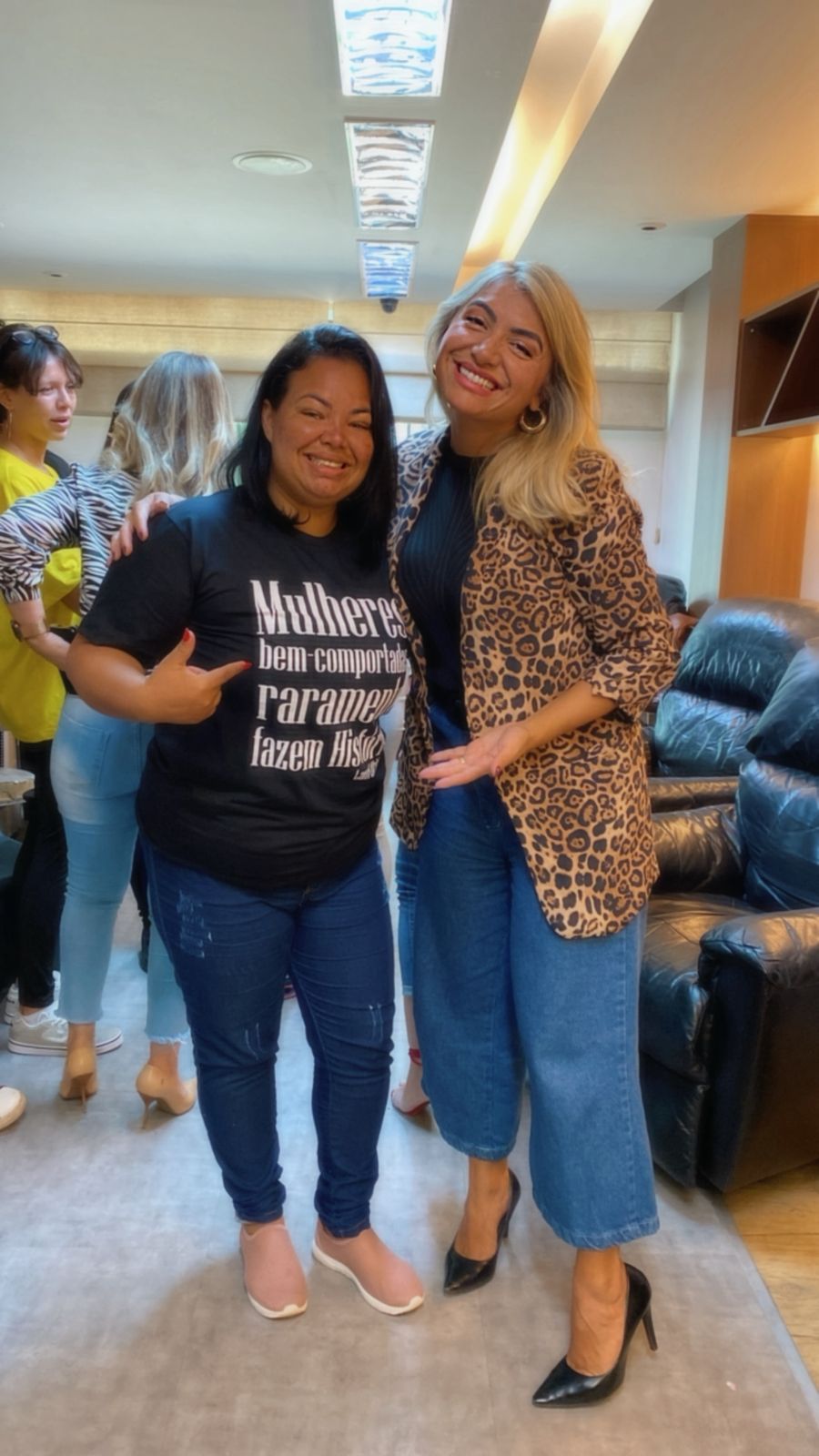 Liza Lopes ao lado de uma participante que veste camiseta com a frase sobre mulheres que fazem história.