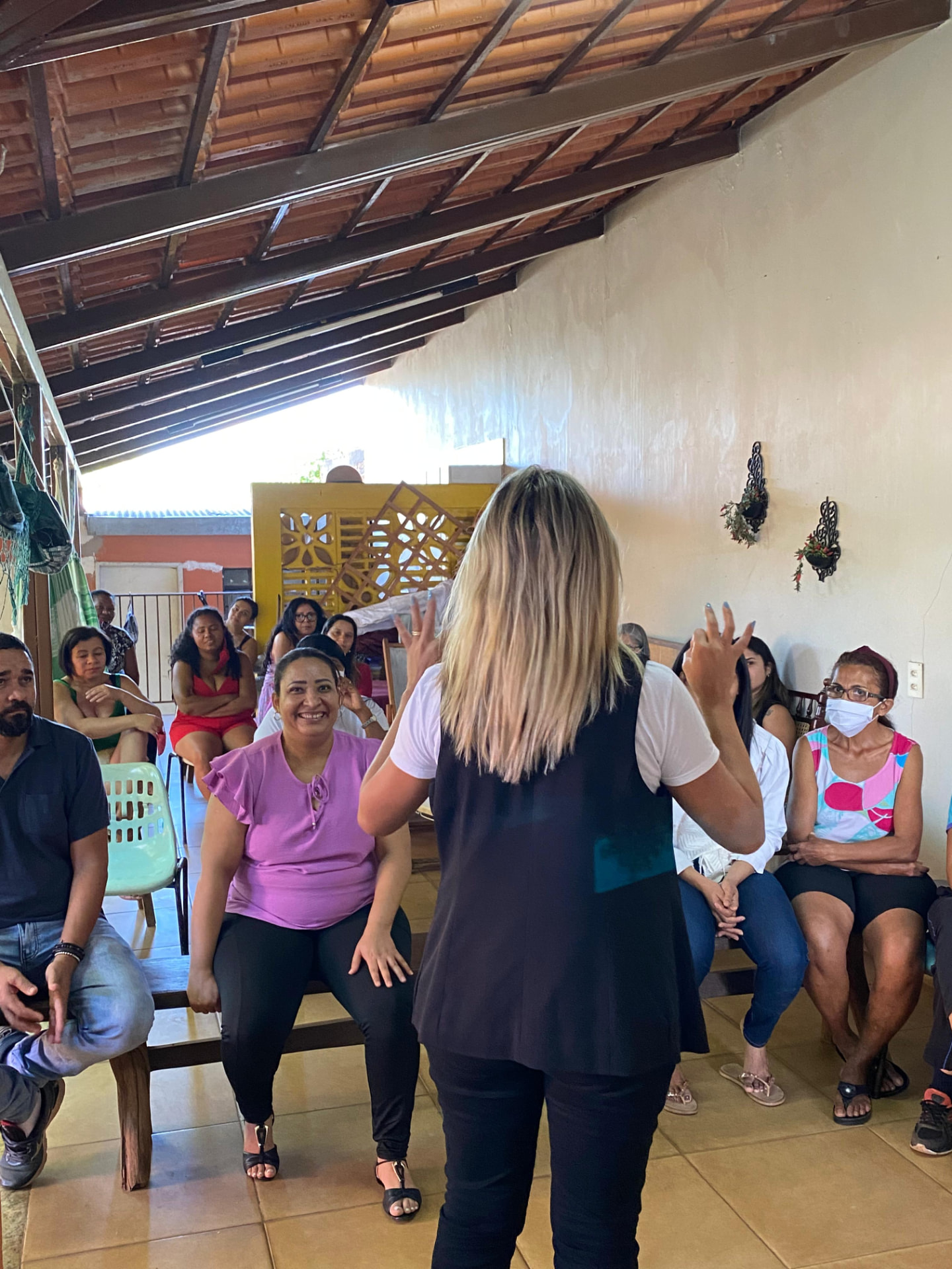 Liza Lopes conduz uma roda de conversa com moradores sentados em círculo.